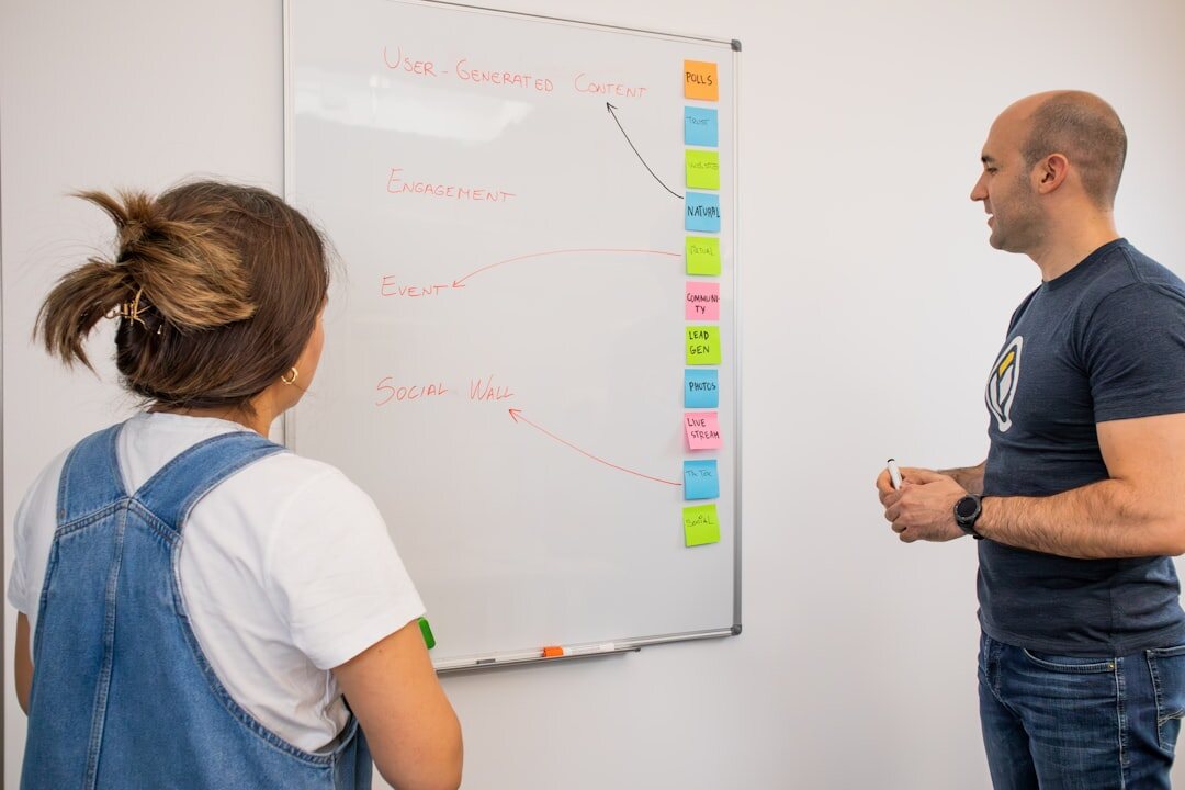 Journalism instructors in a team briefing with whiteboards and notes